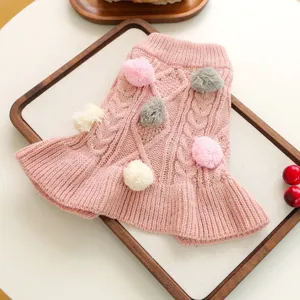 Pink knitted pet dress with cute pom poms, cozy winter sweater for small dogs and puppies, detail.