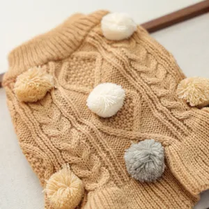 Detailed view of the warm knitted pet sweater with cute pom-pom decorations and cable knit.