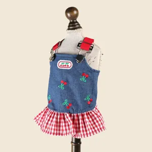 Close-up details of cute pet denim strap dress featuring sweet cherry embroidery and check hem.