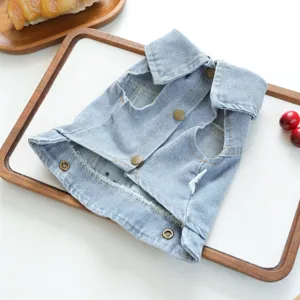 Detailed view of light blue denim pet vest featuring classic lapel and metal snap buttons.