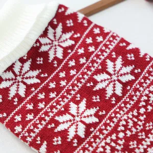 Detailed view of red and white knit pet clothing with classic snowflake pattern for winter season.