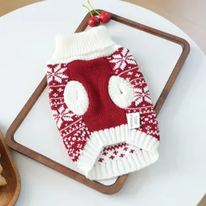 Detailed close-up of a red and white knitted pet sweater with classic winter snowflake pattern.