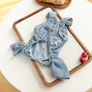 Closeup of cute pet denim strap jumpsuit with metal buttons and embroidered heart details.