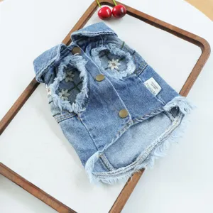 Detailed view of denim pet puppy jacket with cute floral embroidery and frayed collar design.