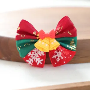 Nahaufnahme des niedlichen Weihnachtshaarclips fuer Haustiere mit rot-gruener Schleife.