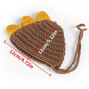 Gros plan sur le chapeau pour animal de compagnie dinosaure au crochet avec pointes jaunes.