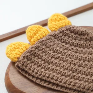 Vue détaillée du bonnet pour animal en crochet marron fait main avec épines de dinosaure