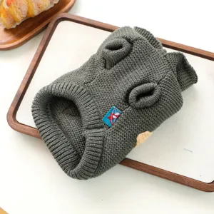 Detailed close-up view of a dark grey knitted pet sweater with comfortable hood on wooden tray.