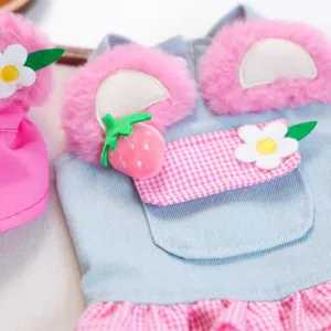 Close-up detail of cute pet denim skirt with pink plush and strawberry decoration for small dogs.