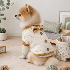 Cute Pomeranian dog wearing a cream knitted pet sweater with a back bow and wooden buttons.