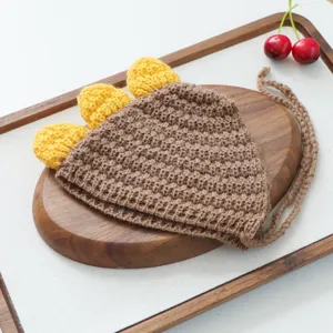 Vue detaillee du joli bonnet tricote pour animal de compagnie avec epines jaunes et lanieres.