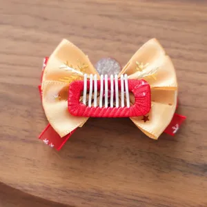 Schöne Haarklammer für Haustiere mit goldener Schleife und Schneeflocken für Hunde.