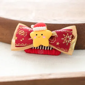 Nahaufnahme Detailansicht der niedlichen Weihnachtshaarspange fuer Haustiere mit roter Schleife.
