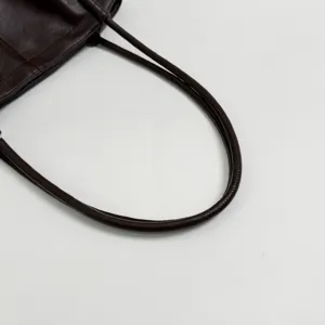 Dark brown oil wax leather tote bag shoulder strap detail closeup view fashion accessory
