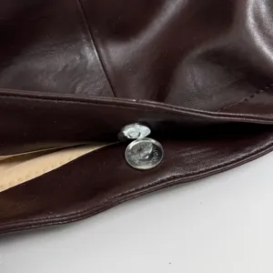Detailed view of the magnetic snap button and premium leather texture for the casual shoulder bag.