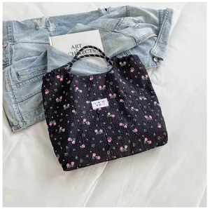 Floral crinkle tote bag detail showing dark fabric with pink flower print and shoulder straps.