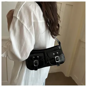 Black patent leather underarm baguette shoulder bag with dual front pockets and metal buckles.