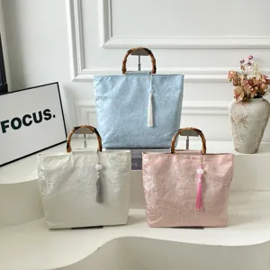 Detailansicht der Leinen-Handtasche im chinesischen Stil mit Bambusgriffen und Quasten.