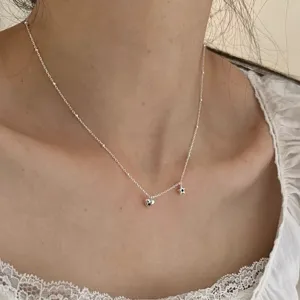 Gros plan d'un collier en argent délicat avec des pendentifs cœur et étoile et des zircons noirs.