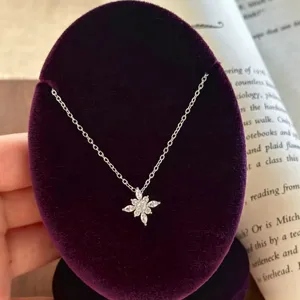 Detaillierte Nahaufnahme der funkelnden Zirkon Blumen-Halskette auf violettem Samt.
