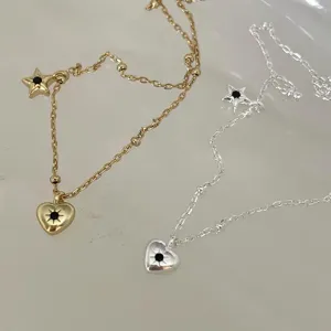 Vue détaillée de colliers cœur étoile en argent et or avec zircons noirs. Style doux et cool.