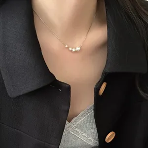 Détail de collier ras du cou en argent avec perles dégradées, style élégant et minimaliste.