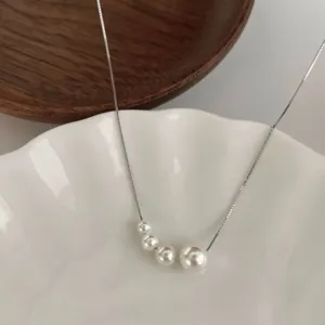 Collier chaîne en argent avec perles blanches élégantes graduées, style français minimaliste.