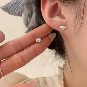 Gros plan détaillé de boucles d'oreilles cœur en argent S925 avec bord perlé délicat.