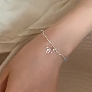 Gros plan détaillé du bracelet ondulé en argent sterling avec joli pendentif fleur.