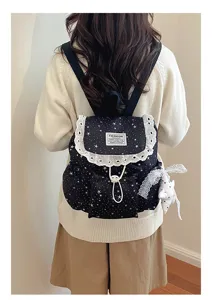 Vue détaillée du sac à dos étoilé noir avec volants en dentelle et pendentif.