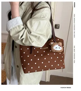 Primo piano della borsa tote marrone a pois in camoscio con ciondolo peluche per tutti i giorni.