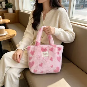 Vista dettagliata della comoda borsa in peluche rosa con tessuto morbido e doppi manici.