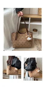 Vista dettagliata della borsa tote marrone a pois con ciondolo orsetto di peluche e logo.