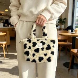 Dettaglio borsa in peluche accogliente, borsa shopper soffice con motivo a cuore per le donne.