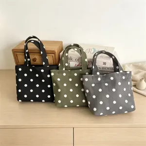 Detailed view of mini polka dot canvas tote bags in three colors, perfect for use.