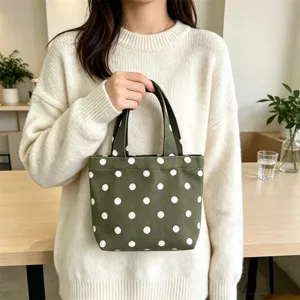 Green canvas polka dot mini tote bag detail showing texture and portable design for daily use.