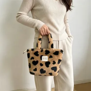 Vista dettagliata della graziosa borsa in peluche marrone con motivi a cuore nero.
