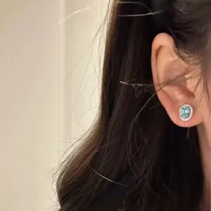 Detailaufnahme der funkelnden ovalen blauen Zirkon Ohrstecker in einer Nahaufnahme.