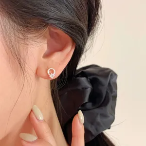Gros plan détail d'une boucle d'oreille clou en argent avec zircone cercle minimaliste.