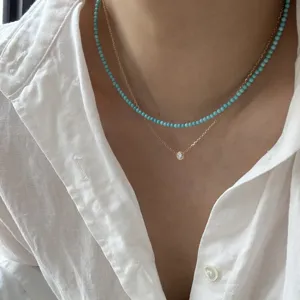 Minimalistische Türkis Perlenkette und zarte Solitär Anhänger Lagenkette im Detailansicht.
