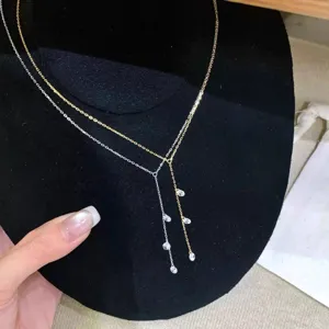 Vue détaillée d'un collier pendentif à pampilles en cristal argenté et doré en Y.