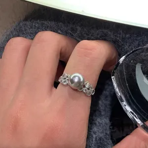 Gros plan du bague en perle montrant la perle centrale lisse et des cristaux de zircone.