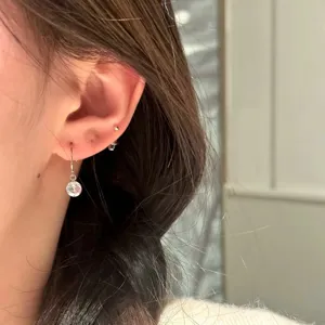 Gros plan detaille de elegantes boucles d'oreilles pendantes minimalistes en argent S925.