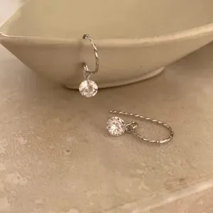Gros plan détaillé des boucles d'oreilles vintage minimalistes en argent sterling.