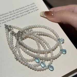 Bracelet de perles en argent S925 exquis avec pendentifs en cristal bleu détail.