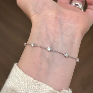 Nahaufnahme eines funkelnden Zargenfassung-Armbands, das stilvoll am Handgelenk getragen wird.