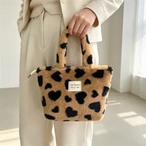 Vista dettagliata della borsa in peluche soffice con grazioso motivo a cuore nero ed etichetta.