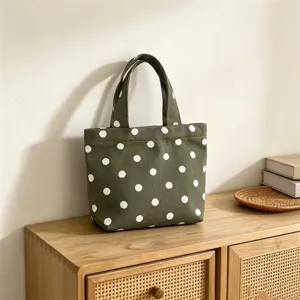 Detail view of a green canvas polka dot tote bag, elegant design for casual daily use.