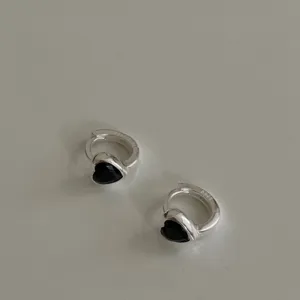 Gros plan détaillé des boucles d'oreilles créoles cœur noir zircon argent S925, design délicat.