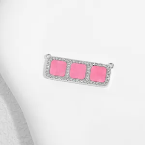 Nahaufnahme des Kupfer Zirkonia rechteckigen Verbinders mit rosa Steinen Detail.